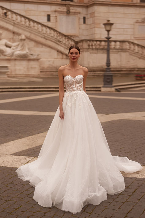 Reveal your tenderness wearing the charming Fantasy gown. The semi-sheer corset, accentuated by exposed boning and structured bust cups, captivates from the first glance. Intricately adorned with floral lace and beads, the bodice seamlessly transitions onto the skirt, creating a mesmerizing cascade.

#ariabride#straplessdress#floralweddinggown#weddingdress2025#newcollection Fashionable Wedding Dresses, Lace And Beads, Sheer Corset, Embroidered Wedding Dress, Wedding Dresses Corset, Endless Love, Fashion Group, Love Wedding, Wedding Dress Styles