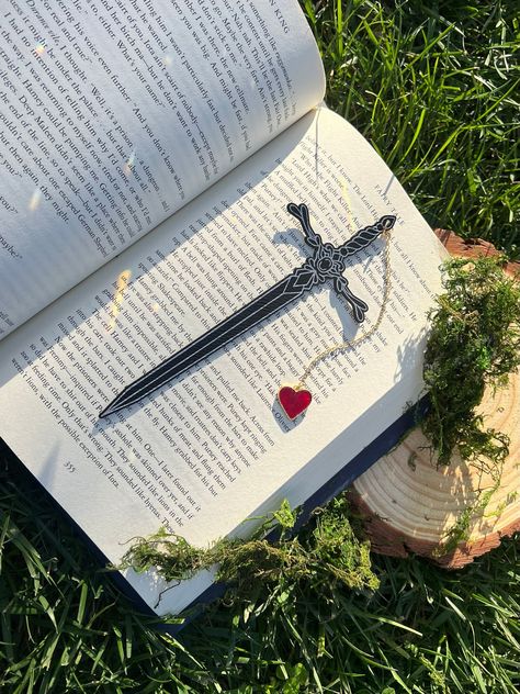 Engraved Leatherette Sword Bookmark, Fantasy Bookmark, Elven-Inspired Bookmark, Gift for Readers, Elf Fairy Faerie Fae Bookmark Make your reading a little extra magical with this beautiful engraved faux leather bookmark with a metal heart tassel. This bookmark is engraved in my home workshop on faux leather leatherette that engraves into a light silver color. HANDCRAFTED IN THE USA- Made in Los Angeles, California by a small, family-owned business NATURAL VARIATION DISCLAIMER- due to the unique nature of the materials we work with, no two items will look exactly the same. There may be slight differences in color, grain, etc that are characteristic of the wood since no two trees are the same. Book Tabs Ideas, Bookmarks Handmade Aesthetic, Faux Leather Bookmark, Make Bookmarks, Bookmarks Ideas, Heart Tassel, Cool Bookmarks, Fantasy Bookmarks, Bookmark Diy