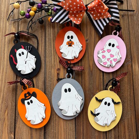 Transform your tree into a spooky centerpiece with our handmade Halloween-themed ornaments! These unique decorations are perfect for adding a festive touch to your home this season. Featuring fun and frightful designs--like pumpkins, ghosts, witches, and more--each ornament is crafted with care and attention to detail, ensuring your Halloween tree stands out. Whether you're going for a playful or eerie vibe, these ornaments are the perfect addition to your spooky setup. Ideal for Halloween lovers who want to celebrate in style, they'll bring a ghoulish glow to any room! 🎃 Product Features: Handcrafted with premium materials: Laser cut birch plywood with coordinating ribbon and matching bead.  All hand painted and embellished. Unique, fun, and spooky designs Lightweight and easy to hang Pe Ghost Ornaments, Themed Ornaments, Unique Decorations, Tree Stands, Halloween Tree, Halloween Lovers, Spooky Designs, Halloween Trees, Halloween Ornaments