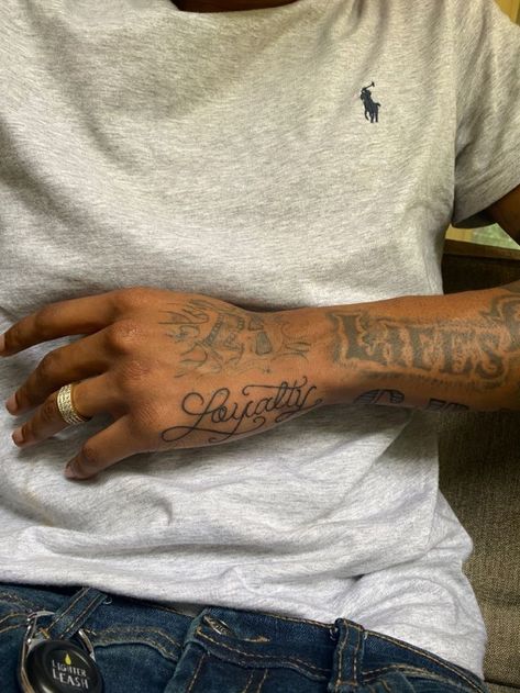 Loyalty Arm Tattoo Men, Loyalty Tattoo With Roses, Loyalty Tattoo On Hand, Writing Hand Tattoos For Guys, Loyalty Over Money Tattoo, Hand Tattoos On The Side, Aesthetic Black Tattoo, Loyalty Hand Tattoos For Guys, Loyalty Arm Tattoo