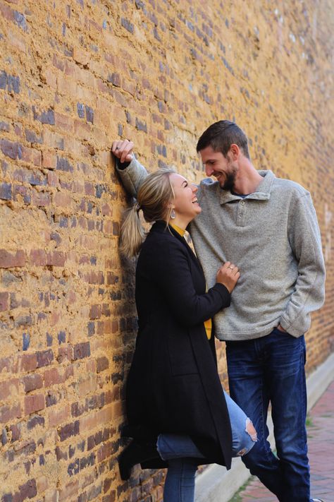 brick wall, smile, fall, couple, engaged, happy Leaning Couple Pose, Engagement Photos With Brick Wall, Couple Poses Against Wall, Brick Wall Couple Photoshoot, No Touch Couple Poses, Brick Wall Engagement Pictures, Brick Wall Wedding Photos, Engagement Photos Brick Wall, Older Couple Photoshoot Poses Outdoors