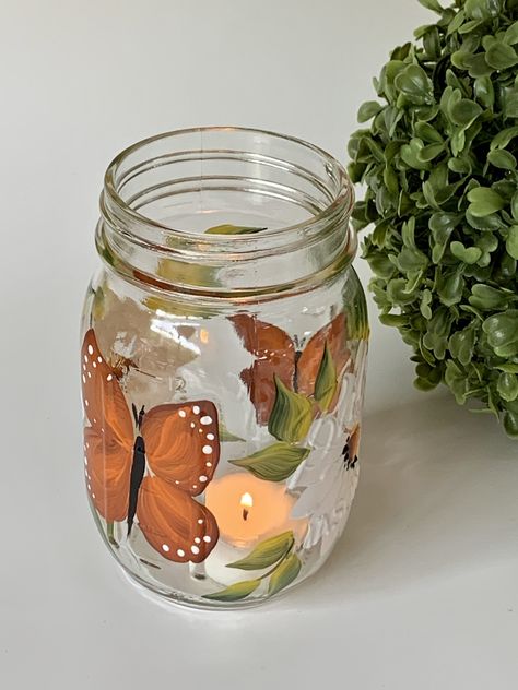 Glass mason jar with handpainted white daisies and butterflies, very happy design. Listing is for one jar with light. They are great as a decorative piece. Remove lights and use for candy or cookies. Wonderful for the bathroom as a toothbrush holder, great for spring and summer, very neutral. Great to use for mixed drinks, wine , sangria etc. Makes a great lemonade jar. Multiple usages, pretty and useful! They are great for gift giving, Jar Painting Ideas Cute Aesthetic, Cute Jar Painting Ideas, Cute Mason Jar Painting Ideas, Painted Mason Jar Ideas, Light Up Mason Jars, Jar Painting Ideas Cute, Mason Jar Painting Ideas, Glass Jar Painting, Painting Mason Jars