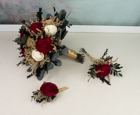 Winter wedding arrangements made of sola flowers, dried flowers, and preserved eucalyptus. Soft wooden flowers in deep red, gold and ivory, with gold painted dried flowers and preserved eucalyptus greenery. Stems with satin ribbon. Smells wonderful!  Will serve you on your Big Day and a long time after.  MADE ON ORDER Dimensions:  BRIDAL BOUQUET                            height approx. 28 cm(11 1⁄32"),                             diameter approx. 25cm(10") MEDIUM BOUQUET Gold And Red Bouquet, Red And Gold Flower Centerpieces, Wedding Burgundy And Gold, Winter Wedding Gold, Wedding Bouquets Red, Medium Bouquet, Ivory Bouquet, Red Bridal Bouquet, Gold Bouquet