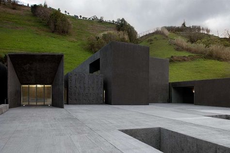 A charcoal-hued pool complex rises from the ashes of a former sports field in Povoação, Portugal—a town know for its  volcanic beach. Slabs of monolithic-sized basalt rock emerge from the nearby hillside and run alongside the slope as if a continuation of it. Spa Architecture, Beer Spa, Portuguese Architecture, Basalt Rock, Rise From The Ashes, Amazing Buildings, Bath House, Beautiful Architecture, Architectural Digest