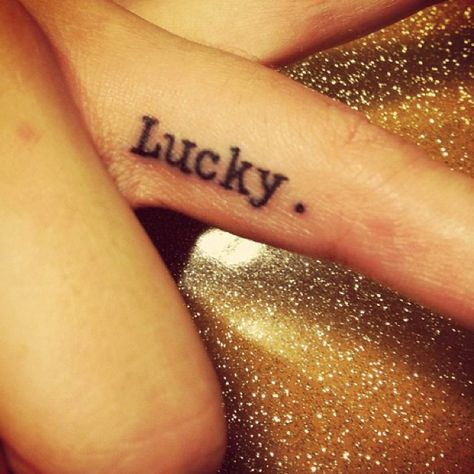 Lucky. Good Luck Knuckle Tattoo, Lettering For Finger Tattoos, Lucky Wrist Tattoo, Lucky Tattoo Word, Finger Tattoo Font Lettering, The Word Lucky Tattoo, Finger Tattoos Words, Peach Tattoo, Lucky Tattoo