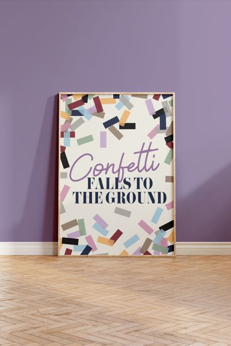 The poster has an off white background with a border of illustrated confetti in the 10 different colours for each Taylor Swift album. In the centre the word "confetti" is written in a light purple script font and then "falls to the ground" in a bold navy font underneath. The image shows the poster in a thin, light wooden frame leaning against a purple wall on  wooden parquet flooring. Taylor Swift Confetti Ideas, Taylor Swift Confetti, Taylor Swift Birthday, Star Confetti, Taylor Swift Posters, Download Poster, Long Live Taylor Swift, Live Taylor, Queen Bee