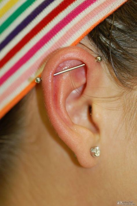 Industrial piercings are one of the most popular body modifications. Learn all about them in this Industrial Piercing FAQs article. Industrial Ear Piercing Ideas, Small Industrial Piercing, Fake Industrial Piercing, Industrial Piercing Aesthetic, Face Dermal Piercing, Face Dermal, Dream Piercings, Industrial Bar Piercing, Ear Piercings Industrial