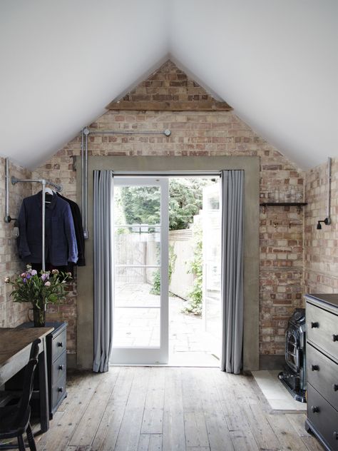 In the back of the garage, new curtained French doors serve as the entrance: A short walk across the terrace leads to the main house. The concrete door surround is a detail Lewis also introduced around the bathroom door. Garage Bedroom Conversion, Garage To Bedroom, Garage Conversion Ideas, Remodel Garage, Garage To Living Space, Garage Floor Paint, Small Bedroom Remodel, Converted Garage, Garage Room