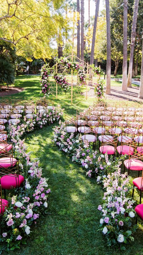 Winding ceremony aisle with pink chairs and spring floral with an enchanted gate as the ceremony backdrop. Dreamy wedding inspiration for an enchanted garden theme. Spring Fairy Wedding Theme, Winding Wedding Aisle, Secret Garden Wedding Theme, Enchanted Garden Theme, Fairy Wedding Theme, Wedding Ceremony Aisle, Wedding Aisles, Garden Elopement, Pink Chairs