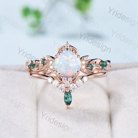 Vintage White Opal Engagement Ring Set Unique Leaves Nature Inspired Emerald Wedding Ring Set Art Deco Green Crystal Moissanite Bridal Set ≫≫ Item Details  Make every ring to order, all rings are handmade in the United States.  Metal: Solid 10K & 14K & 18K Gold  Gold Color: Rose gold, Yellow gold, White gold The default photo is made in 10k white gold ➽ Center Stone 6.5mm round  cut Lab white opal ➽ Accent Stone:lab created emerald and moissanite Matching Band: marquise lab emerald + round cut m Opal Stone Engagement Rings, Green Opal Engagement Ring, Opal Wedding Ring Set White Gold, Opal Emerald Engagement Ring, Wedding Rings Engagement Opal, Unique Engagement Rings Opal, Opal And Emerald Engagement Ring, Emerald Opal Engagement Ring, Exquisite Wedding Ring With Accent Stones