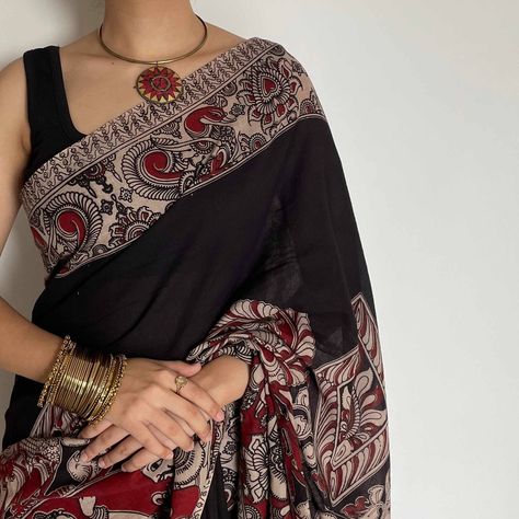 This isn't just a saree, it's a conversation starter. The intricate Kalamkari work on our Urmi mulmul saree whispers stories of heritage, its black, cream, and red hues a captivating combination. Imagine the compliments turning into questions... "Where did you get that stunning saree?" You can proudly tell them, "It's a Shobhangini Urmi, a piece of India's vibrant culture!" Shop Urmi now and embrace the magic of tradition. #Shobhangini #MulmulSaree #Kalamkari #BlackAndRedSaree #HeritageSa... Everyday Saree, Black And Red Saree, Saree Modern, Black Cotton Saree, Mulmul Saree, Kalamkari Dresses, Kalamkari Blouse, Cotton Saree Blouse Designs, Cotton Saree Designs