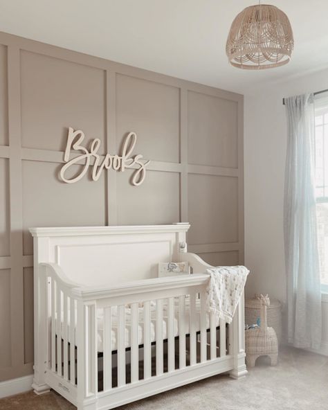 A vision of elegance. Our Palermo Crib was designed to make a statement, with graceful molding that reminds us of palatial suites 👑 DIY aficionado @mrsdesignerella knew just how to accentuate AND complement its refined form, opting for a taupe board and batten backdrop and modern boho accessories made of rattan. Nursery Two Cribs, Tan Accent Wall Nursery, Waynescotting Nursery, Textured Nursery Wall, Vertical Wood Accent Wall Nursery, Wallpaper Ideas Nursery, Paneled Nursery Wall, Modern Girl Nursery Ideas, Board And Batten Wall For Nursery