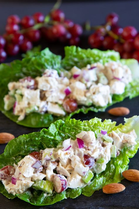 a close up image of creamy chicken salad inside of a romaine lettuce leaf with red grapes in the background Low Calorie Chicken Salad, Romaine Lettuce Recipe, Easy Chicken Lettuce Wraps, Chicken Salad Lettuce, Lettuce Wraps Healthy, Lettuce Recipes, Chicken Salad With Grapes, Chicken Lettuce Wraps Recipe, Low Calorie Chicken