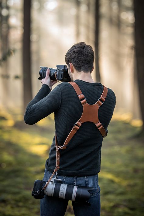 Handmade leather camera harness, photographer with sunset using a dual camera holster Leather handmade Camera Strap, Camera Harness, personalized dual camera holster, custom leather camera harness, Accessory for professional photography, Camera neck and shoulder straps, Quality leather harnesses and straps for photographers, Leather camera neck and shoulder straps, photography accessories, personalized with your logo or personal design Leather Camera Harness, Male Photographer Aesthetic, Camera Holster, Professional Photography Camera, Leathercraft Ideas, Camera Harness, Diy Leather Projects, Photography Accessories, Leather Harness