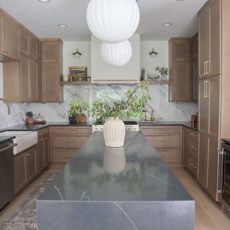 Narrow kitchen island design with soapstone quartz and waterfall countertop. Styled with a rustic pottery vase and sprawling greenery branches. Modern Vintage Kitchen, Glass Shelving Unit, Waterfall Island Kitchen, Kitchen Renovation Design, Modern Kitchen Renovation, Dark Countertops, Narrow Kitchen, Countertop Decor, Island Countertops