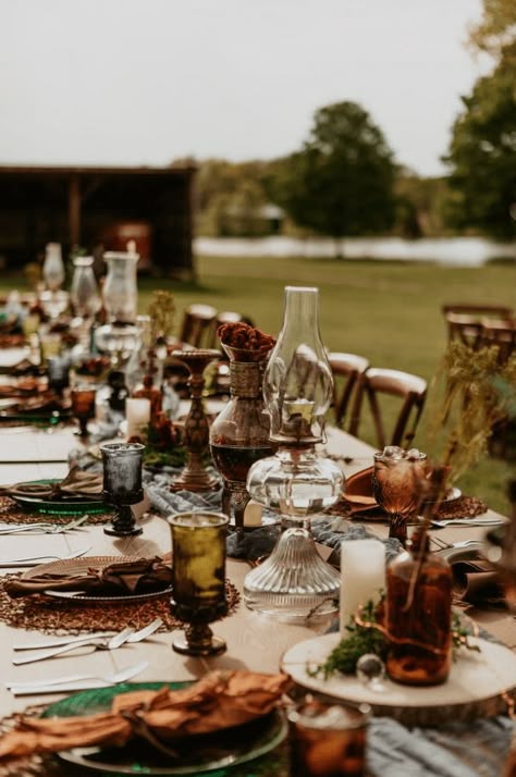 This moody cottage core wedding had the perfect al fresco tablescape! We love the vintage glassware and foraged florals. Check out more outdoor dining ideas on our blog. Boho Thrifted Wedding, Bohemian Table Setting Wedding, Cottage Core Forest Wedding, October Moody Wedding, Fall Wedding Farmhouse, Thrifted Wedding Bridesmaid Dresses, Earthy Wedding Inspiration, Antique Rustic Wedding, Antique Wedding Table Setting