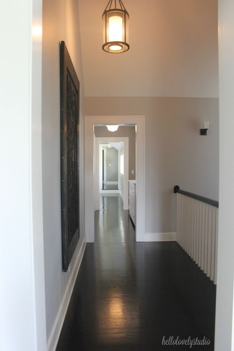 Black flooring, medium grey paint colors, and magnificent architecture in a second floor landing of an industrial farmhouse. #interiordesign #paintcolors #industrialfarmhouse #blackfloors Medium Grey Paint Colors, Industrial Farmhouse Interior Design, Industrial Farmhouse Interior, Grey Painted Floor, Farmhouse Interior Design Ideas, Grey Interior Paint, Black Flooring, Moulding Ideas, Magnificent Architecture