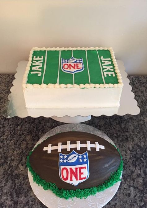 Football themed first birthday with football shaped smash cake One Year Down Football Birthday Cake, Football 1st Birthday Party Smash Cakes, Football First Birthday Smash Cake, First Down Football Birthday Party Cake, First Birthday Football Theme Cake, 1st Birthday Football Theme Cake, Football 1st Birthday Cake, Football Themed Smash Cake, 1st Birthday Football Cake