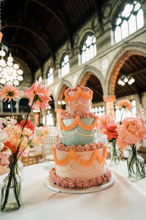 Brightly coloured retro styled three tier wedding cake complete with ruffled icing beside colourful floral arrangements Bold Wedding Cake, Wedding Cake Colourful, Colorful Vintage Wedding Cake, Quirky Wedding Cake, Maximalist Wedding Cake, 70s Wedding Cake, Bright Wedding Cake, Colourful Wedding Cake, Wedding Cake Aesthetic