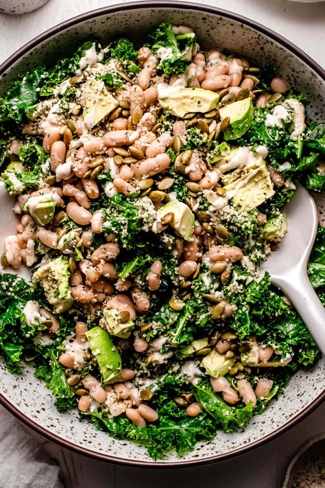 This copycat Erewhon Kale White Bean Salad tosses kale, avocado, cannellini beans, and seeds in a lemony tahini dressing. A must-try healthy lunch, light dinner, and satisfying side dish! White Bean And Kale Salad, Kale And Avocado Salad, Whole Foods Kale Salad Recipe, No Dairy Salad, Erewhon Kale White Bean Salad, Erewhon Kale Salad, Kale White Bean Salad, Kalettes Salad, Creamy Salad Recipes