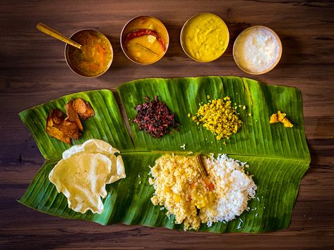 Sapad is South Indian meal. Served on a banana leaf, the banana leaf is laid so that the leaf tip is pointed left. Before anything is served you have to sprinkle water and clean it. The top half of the banana leaf is reserved for accessories dishes and the lower half for the rice. Accessories: fried chips, aplam, poriyal, chutney Server serves, yellow daal(lachka), then rassam, then sambar, then curd.  P.S: If it is not served as per rule my husband gets annoyed. And in picture I served with one Banana Leaf Rice, Banana Leaf Plates, South Indian Thali, Indian Food Photography, Recipes Using Bananas, Indian Meal, India Food, Indian Street Food, Exotic Food