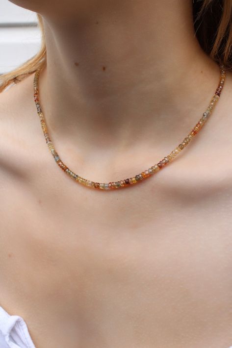 The gradient of this zircon-beaded necklace captures the turn of seasons. 'Solstice' reminds us of impermanence and the beauty that comes with such fluidity. As summer unfurls into autumn, the colours of these faceted beads carry earth tones of amber, brown, buttery yellow and pale blues, reflecting such changes. Hand-strung and designed by us in our flagship store in Vancouver, BC, we personally sourced these zircon beads with the intention of creating a piece that is wearable and uniquely yours. The piece is finished with a sturdy 10k yellow-gold lobster clasp. Enjoy this pretty beaded necklace paired with your favourite gold chains and charms. Details: 10k yellow gold lobster clasp + Zircon beads 16.5" in length Code: ZIRCON165 (TAE) Necklace Beads Design, Autumn Beaded Necklace, Autumn Beaded Jewelry, Earth Tone Jewelry, Fall Bead, Autumn Jewelry, Autumn Necklace, Beaded Necklace Designs, Amber Brown