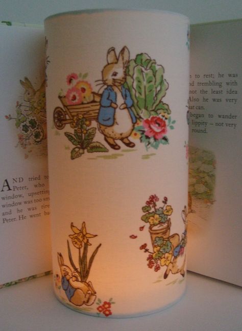 Beatrix Potter Peter Rabbit vintage print- Handmade Tall Nursery Night Light.   Such a delightful vintage print featuring Peter Rabbit in MR McGregor's  Garden, simply lovely lit up. and would make lovely baby shower gift. Night Light comes with Battery powered Tea Lights, completely safe, no risk of burning no melted wax or fumes, simply switch on and off as desired. Night Light comes with two Battery Tea Lights lasting 120 hours each =240 hours. Night Light measures 10cm in diameter 20cm high. Beatrix Potter Nursery Ideas, Vintage Peter Rabbit Nursery, Rabbit Kindergarten, Beatrix Potter Nursery, Rabbit Vintage, Battery Tea Lights, Peter Rabbit Nursery, Childrens Night Light, Rabbit Family