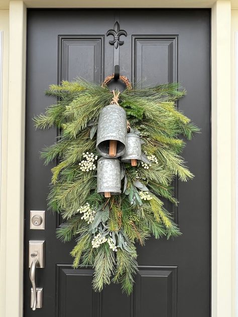 Our Silver Bells Christmas Pine Swag Wreath is the perfect combination of holiday tradition and rustic elegance. The trio of vintage metal bells adds a charming, old-world feel, while the evergreen branches and white berries create a serene winter scene. Hang it on your covered front door to bring the sound of Christmas into your home, filling the air with peace and goodwill. Holiday Window Wreath And Swag, Bells For Wreaths, Front Door Garland Uk, Christmas Wreaths Plug In Outsoor, Rustic Christmas Wreath For Front Door Jingle Bells, Rustic Door Swag, Natural Brancg Christmas Over Door, Swag Wreath Hanging, Metal Christmas Wreaths For Front Door