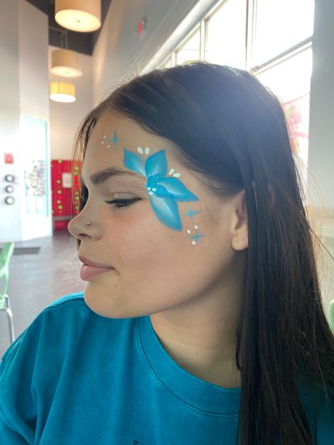 Near eye face painting of a flower Face Paint Birthday Party Ideas, Easy Things To Face Paint, Simple Flower Face Paint, Preppy Face Paint Ideas, Quick And Easy Face Painting For Kids, Super Easy Face Paint, Easy Face Painting For Beginners, Luau Face Painting Ideas, Face Painting Sports