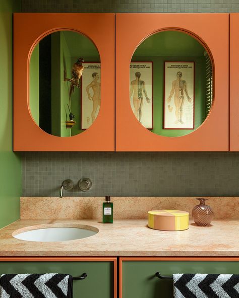 In his Berlin apartment, architect and designer @fabianfreytag chose a spectrum of greens and oranges to devise a punchy, sophisticated take on this retro-inflected colour combination. In the bathroom, Farrow and Ball’s soothing ‘Calke Green’ is offset by peachy cabinetry and a pink marble counter, with monochrome chevron-striped towels adding a dash of graphic pattern to the room. See how the designer applied this daring colour palette to the rest of his home in the current issue, on sale ... Orange And Green Bathroom, Orange Tile Bathroom, Green Colour Combinations, Retro Green Bathroom, Calke Green, Orange Architecture, Green Color Combinations, Orange Bathroom, Berlin Apartment