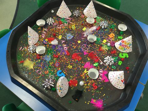 Birthday tuff spot. Includes a party hat for each child, glitter, star sequins, number 5's, cup cake cases, candles, coloured wood chip, spinning tops, Pom Poms, feathers and birthday ribbons! #tuffspot #tufftray Birthday Party Eyfs Activities, Birthday Eyfs Activities, Eyfs Birthday Activities, Birthday Topic Eyfs, Birthday Activities Eyfs, Tuff Tray Party Ideas, Messy Play Party, Birthday Tuff Tray Ideas, Birthdays Eyfs