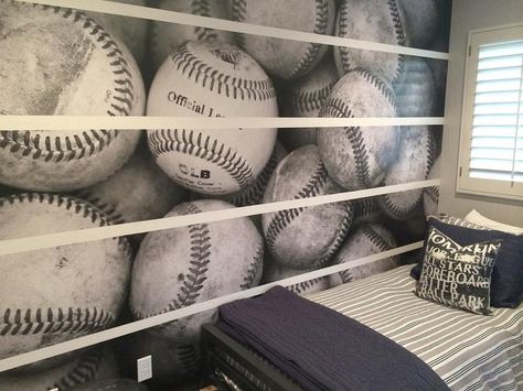 Sports themed kid's bedroom boasts a black and white baseball mural accent wall positioned adjacent to a window framed by gray wall paint. Baseball Mural, Wallpaper For Boys Room, Gray Wall Paint, Boys Baseball Bedroom, Baseball Themed Bedroom, Baseball Theme Room, Wallpaper For Boys, Boys Bedroom Curtains, Sports Room Boys