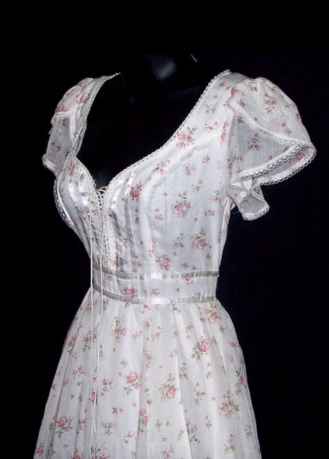 This is a vintage Gunne Sax dress from the 70s. It's made from a cotton blend material with pink roses and a white background. Its trimmed with lace, ribbon, and pearls. The inside is lined. The front laces up like a corset. The corset can be loosened slightly to add a little more room if needed. The bottom has a full skirt with an attached slip underneath. It zips and ties in the back. CONDITION: Great condition, no flaws found. New with tag. ESTIMATED SIZE: XS. The size tag is marked as a 7 in Short Gunne Sax Dress, Gunne Sax Prom Dress, Prarie Dresses 70s, Pink And White Outfit Ideas, Vintage Dresses Aesthetic, Gunne Sax Dress Vintage 70s, Cottagecore Closet, Cotton Wedding Dress, Southern Dress