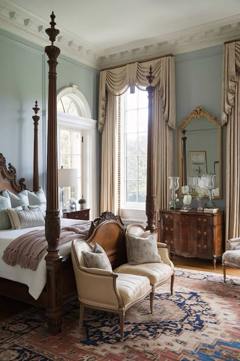 A four-poster bed with carved details sits at the center of this timeless bedroom, surrounded by pale blue walls. Elegant drapes frame tall windows, allowing morning light to flood in. An ornate mirror hangs above a wooden dresser, reflecting the soft glow from a pair of glass lamps. Plush bedding and a Persian rug complete the refined look. Rice Bed Bedroom Decor, Modern Traditional Bedroom Master Suite, Bedroom With Seating Area Master, Castlecore Bedroom, Tall Ceiling Bedroom, Tall Ceilings Bedroom, Married Bedroom Ideas, Romantic Master Bedrooms Decor, Wood Four Poster Bed