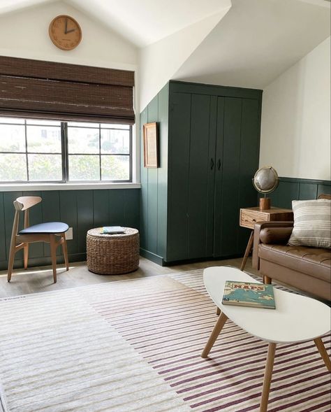 vertical shiplap, green paint, green playroom, kids playroom, wooden woven shades, 1950 beach cottage, modern traditional home, wicker ottoman, globe, brown leather couch, modern coffee table, shared kids bedroom, playroom ideas, playroom inspo Small Living Room Makeover, Green Playroom, Downstairs Playroom, Modern Leather Couch, Boys Shared Room, Living Room Makeover Ideas, Kitchen Renovation Cost, Modern Traditional Home, Brown Leather Couch