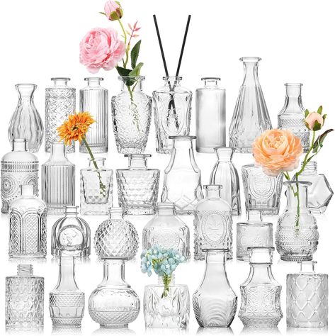 STURDY AND THICK GLASS---30 pcs bulk bud vases are made of high quality thick and strong glass,which are durable and not easy to break. The bottom is non-slip and the center of gravity is stable. These petite little vases were perfect for wedding tables and also be reused for any other table decor or home decor. You can also add some dried flowers or aromatherapy sticks to the vase. ALL UNIQUE DESIGNS AND DIFFERENT SHAPES AND SIZES. Shapes and heights (3-5.5 inches) Vases On Wedding Tables, Bridal Shower Centerpieces Flowers Simple, Pitchers With Flowers Centerpieces, Craft Table Wedding, Bridal Shower Table Center, Painted Vase Wedding Centerpieces, Mini Dried Flower Vases, Dried Flower Bud Vase Centerpiece, Small Table Floral Centerpiece