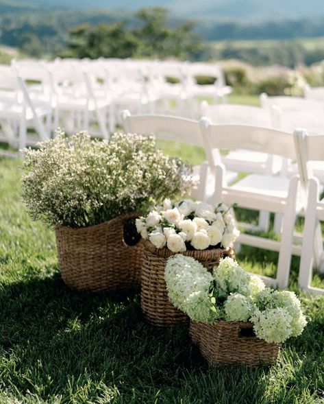 White Wedding Ceremony Chairs, Wedding Inspo Neutral, Baskets With Flowers Wedding, Wedding Flower Basket Ideas, Potted Aisle Flowers, Basket Florals Wedding, Wedding Aisle White Chairs, Flower Pots Wedding Aisle, Basket Wedding Centerpieces