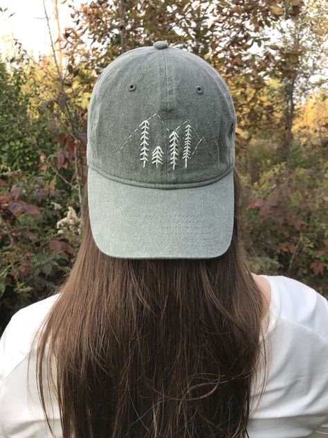 Mountain and evergreen scene stitched in white on an olive green hat. The back features a verse written in white script. Hat Embroidery Ideas, Baseball Hat, Embroidered Hat, Bone Bordado, Mountain Hat, Baseball Cap Outfit, Surfer Girl Style, Hat Embroidery, Embroidered Caps