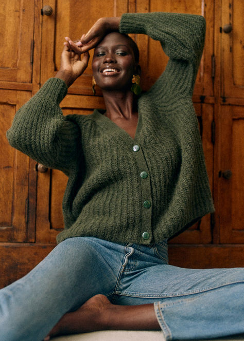 Sézane’s Basile Cardigan in Epicea Green is crafted from a luxurious blend of alpaca and wool. This cardigan features long, slightly puffed sleeves, a slightly oversized fit, and a beaded rib knit for added texture. The V-shaped neckline and faux horn buttons bring a touch of elegance, making it a versatile piece for your fall wardrobe. Style it with jeans or a skirt for a chic look. Check out our latest arrivals at sezane.com or via the app. Green Knit Cardigan, Dark Green Cardigan, Dark Green Color, Denim T Shirt, Green Cardigan, Suit Accessories, Dress Trousers, Fall Wardrobe, Wool Sweater