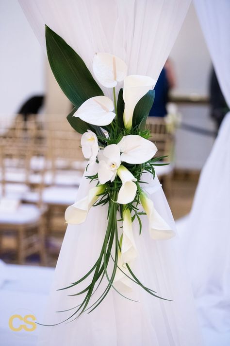 Chuppah floral accent comprised of calla lilies, anthurium, aspidistra,and lily grass for a sleek, modern, and linear look!  Photography https://connorstudios.com/  #jewishwedding #chuppah #modernwedding Pampas Grass And Calla Lily, Lily Flower Wedding Decor, Wedding Calla Lillies Decor, Calla Wedding Decoration, Cala Lily Wedding Centerpieces, Lilies Wedding Decorations, Peace Lily Wedding, Calla Lily Wedding Decorations, Wedding Lilies