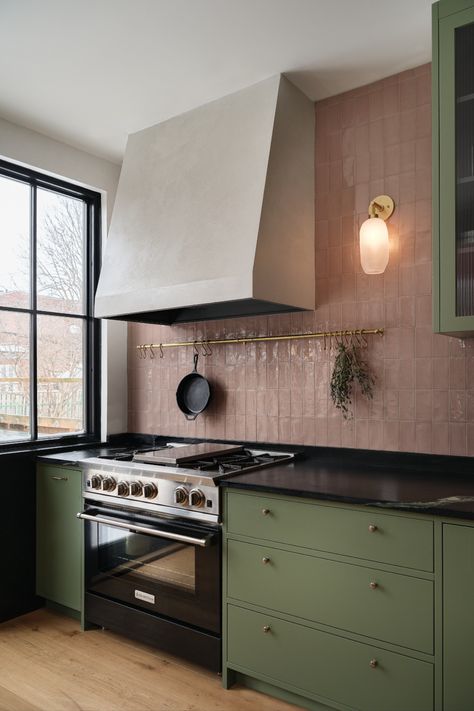 Green kitchen cabinet with pink backsplash and brass details. Gas stove with plaster canopy hood. Kitchens 2023, Pink Kitchen Walls, Green Kitchen Inspiration, Green Kitchens, Best Kitchen Colors, Green Backsplash, Colourful Kitchen, Sage Green Kitchen, Green Kitchen Cabinets