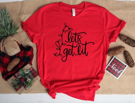 Christmas T-Shirt | Let's get lit | Funny Christmas Tee All of our items are handmade with love💜 Our shirts are made using commercial grade, high quality, Heat Transfer Vinyl. They are pressed with a profession heat press machine to ensure durability of the print. This process gives a long lasting finish to all of our designs. Women: For a woman’s fit, we recommend to go down a size. For a looser fit, stick with your normal size. Men: Stick with your normal size. Returns and Exchanges Policy Ea Family Christmas Outfits, Winter Things, Funny Kids Shirts, Lets Get Lit, Christmas Tee Shirts, Creative Shirts, Matching Sweaters, Christmas Things, Heat Press Machine