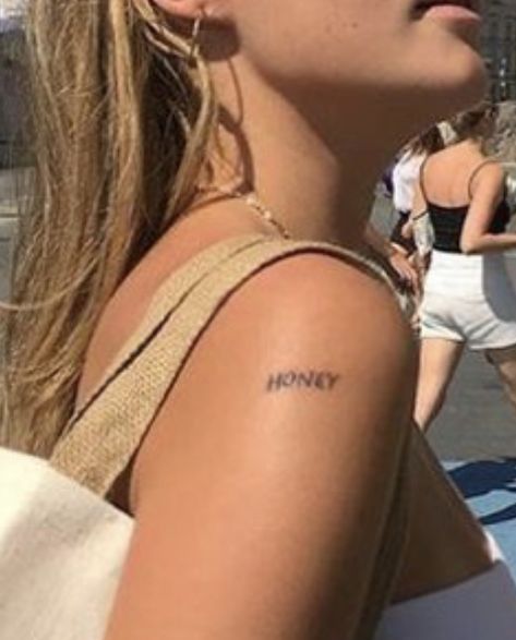 “HONEY” shoulder tattoo Word Tattoo Shoulder, Shoulder Stick And Poke, Shoulder Tattoos Quotes, Words On Shoulder Tattoo, Shoulder Text Tattoo, Honey Stick Tattoo, One Word Tattoos Placement, Shoulder Word Tattoo, Honey Word Tattoo