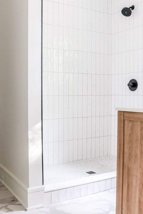 White Shower Walls Black Floor, Tile Over Shower Pan, Verticle Subway Shower Tile, White Subway Tile Shower Ideas Small Bathrooms, Walk In Shower Vertical Tile, White Vertical Shower Tile, Small Subway Tile Bathroom, Penny Tile Shower Floor Ideas, Shiplap And Subway Tile Bathroom