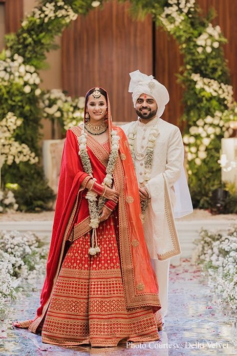 varmala ceremony, couple portrait, white wedding garlands, floral decor, wedding mandap, wedding arch, wedding foliage, Indian wedding, wedding planning, wedding inspiration, traditional wedding, wedding photography, heartfelt ceremony, serene wedding, elegant wedding decor. indian wedding, groom outfit, groom in white, bride in red, traditional bridal look Wedding Groom Outfit, Varmala Ceremony, Varmala Designs, Indian Wedding Groom, Mandap Wedding, Wedding Varmala, Traditional Bridal Look, Groom In White, Wedding Decor Indian