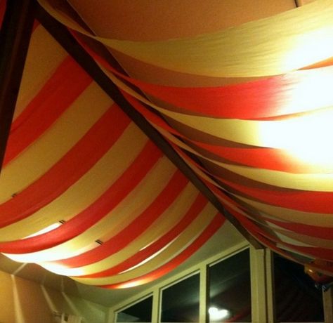 Circus Tent - Drape your wedding venue ceiling in striped carnival colours that creates the illusion that you’re inside a circus tent. From the corners of the ceiling and meeting in the centre, drape red and white striped fabric or table cloths that are cut into broad strips. Diy Circus Tent, Venue Ceiling, Wedding Tent Draping, Diy Wedding Tent, Rainbow Streamers, Diy Carnaval, Theme Wedding Ideas, Tent Diy, Carnival Tent