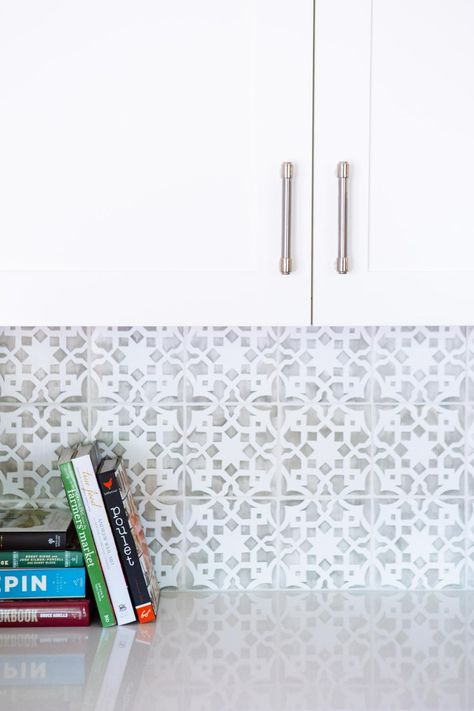 A graphic gray and white tile backsplash is the perfect complement for the crisp white cabinets and solid white countertops in this updated kitchen by Pure Design Interiors. Backsplash For White Cabinets, Backsplash With White Cabinets, Graphic Tiles, Bold Tile, White Kitchen Backsplash, White Tile Backsplash, Unique Backsplash, Herringbone Backsplash, Kitchen Backsplash Designs