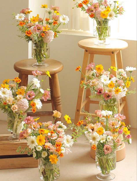 6 vases full of flowers displayed on wooden stools and such. The flowers are white, yellow, and dusty pink with hints of orange. They arranged in a garden style with a  wild whimsical look. Yellow Cosmos, Pink Lisianthus, Yellow Flower Arrangements, Large Vases, Yellow Bouquets, Yellow Wedding Flowers, Baby Shower Yellow, Daisy Wedding, Floral Aesthetic