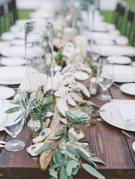 succulents, driftwood, seeded eucalyptus and oyster garland make a perfect coastal feel Seaglass Tablescape, Oyster Table Setting, Oyster Shell Table Decor, Driftwood Table Decor, Simple Beach Wedding Table Decor, Driftwood Centerpiece Wedding, Oyster Wedding Decor, Driftwood Wedding Centerpieces, Coastal Table Setting