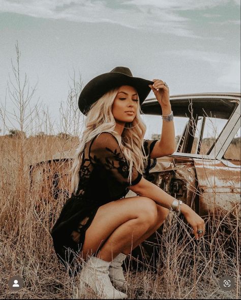 Girl in field, blonde western vibe with black felt cowboy hat and western silver jewelry in black western lace dress and tan cowgirl boots, posed crouched down Fall Photoshoot Western, Western Female Photoshoot, Cowboy Hat Pictures Photo Shoot, Cowgirl Inspired Photoshoot, Western Whiskey Photoshoot, Southern Photoshoot Ideas, Cowgirl Themed Photoshoot, Ranch Photoshoot Picture Ideas, Western Snow Photoshoot